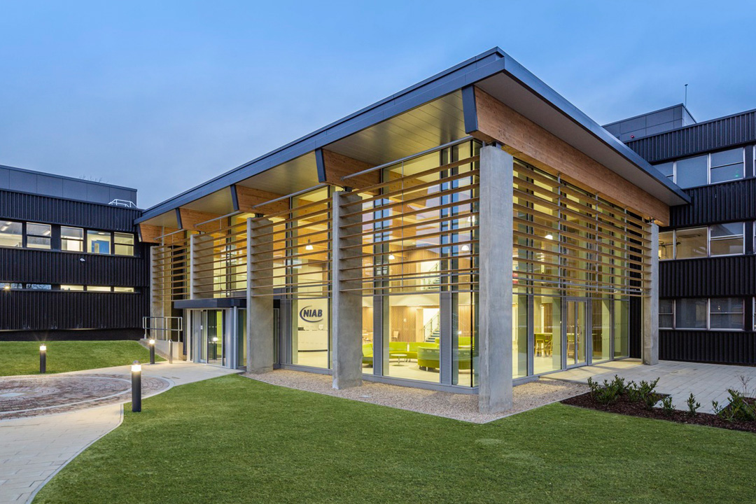 NIAB Exterior Building in Cambridge at dusk. Building entrance with internal lights on.